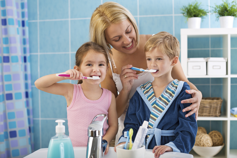 Mother and children brushing teeth