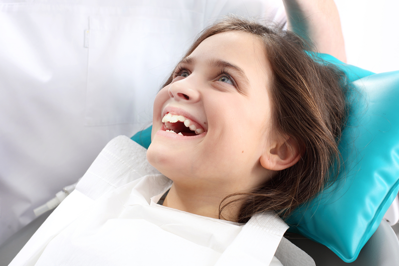 Young girl patient smiling as she is about to have a dental procedure