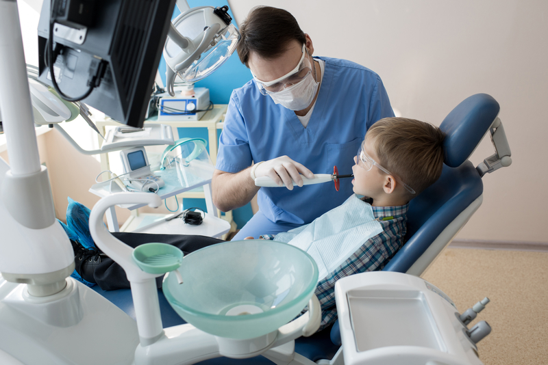 Young patient receiving a dental treatment from a dentist.