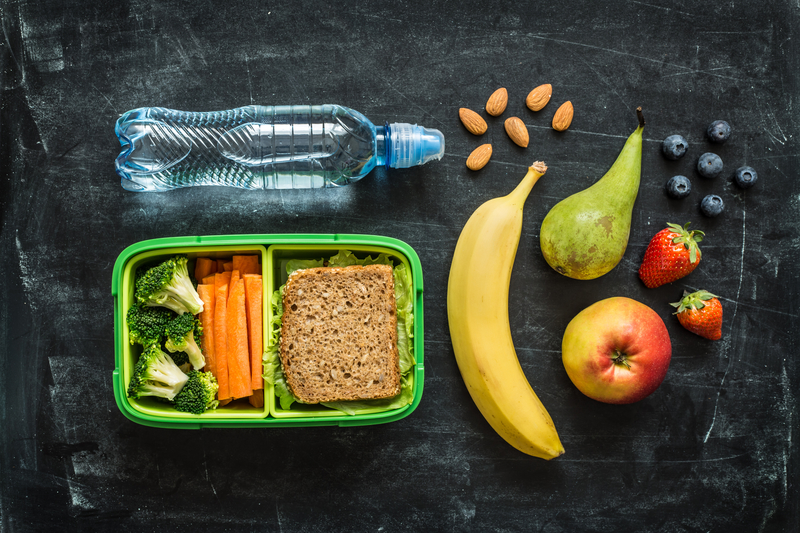 School lunch box with sandwich, vegetables, water, almonds and fruit