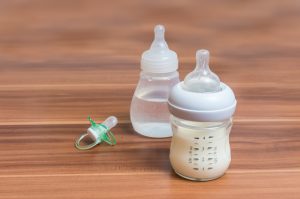 baby bottles; one filled with water and one filled with milk