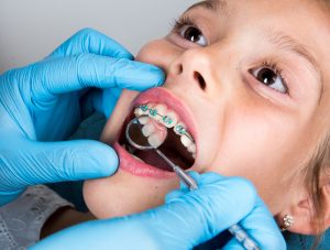 A young patient having their braces looked at in-office.