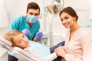 Mother and child in a dental office with a dental assistant