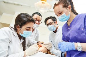 Dental students practicing procedures on a patient