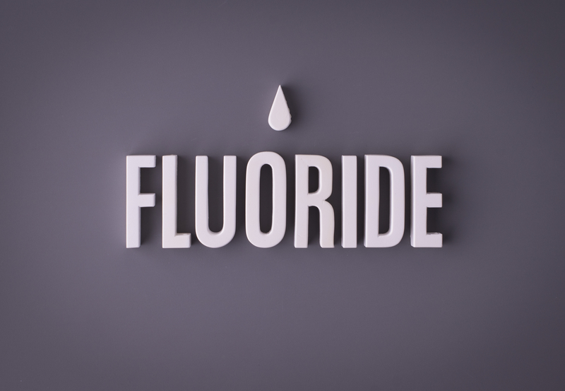 The word fluoride written in block letters with a water droplet above that word. 