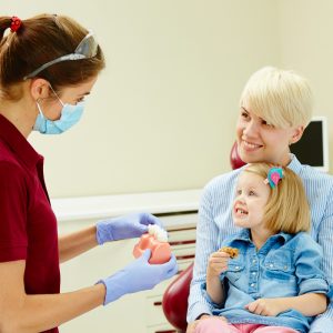 Pediatric dentist visiting with mother and child during dental visit