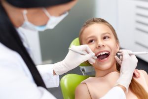 Young boy having his mouth looked at by a dental hygienist.